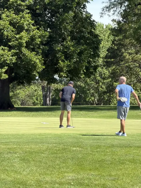 Two golfers finishing out a hole on the green at the 2026 Trojan 2-Man